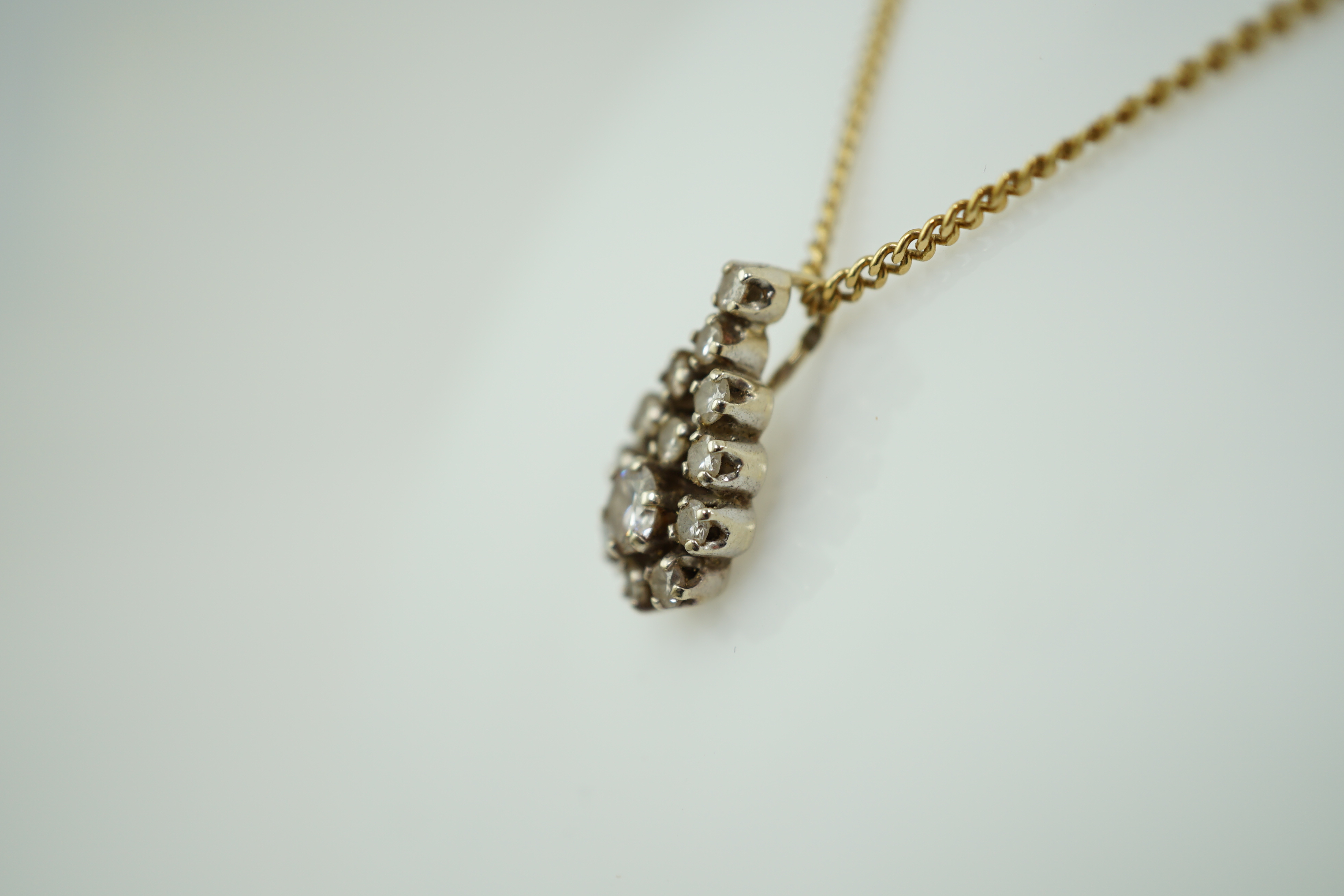 An early to mid 20th century French 18k gold and diamond cluster set pendant, on a French 18k gold chain